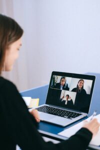 mujer mira pantalla reunión online