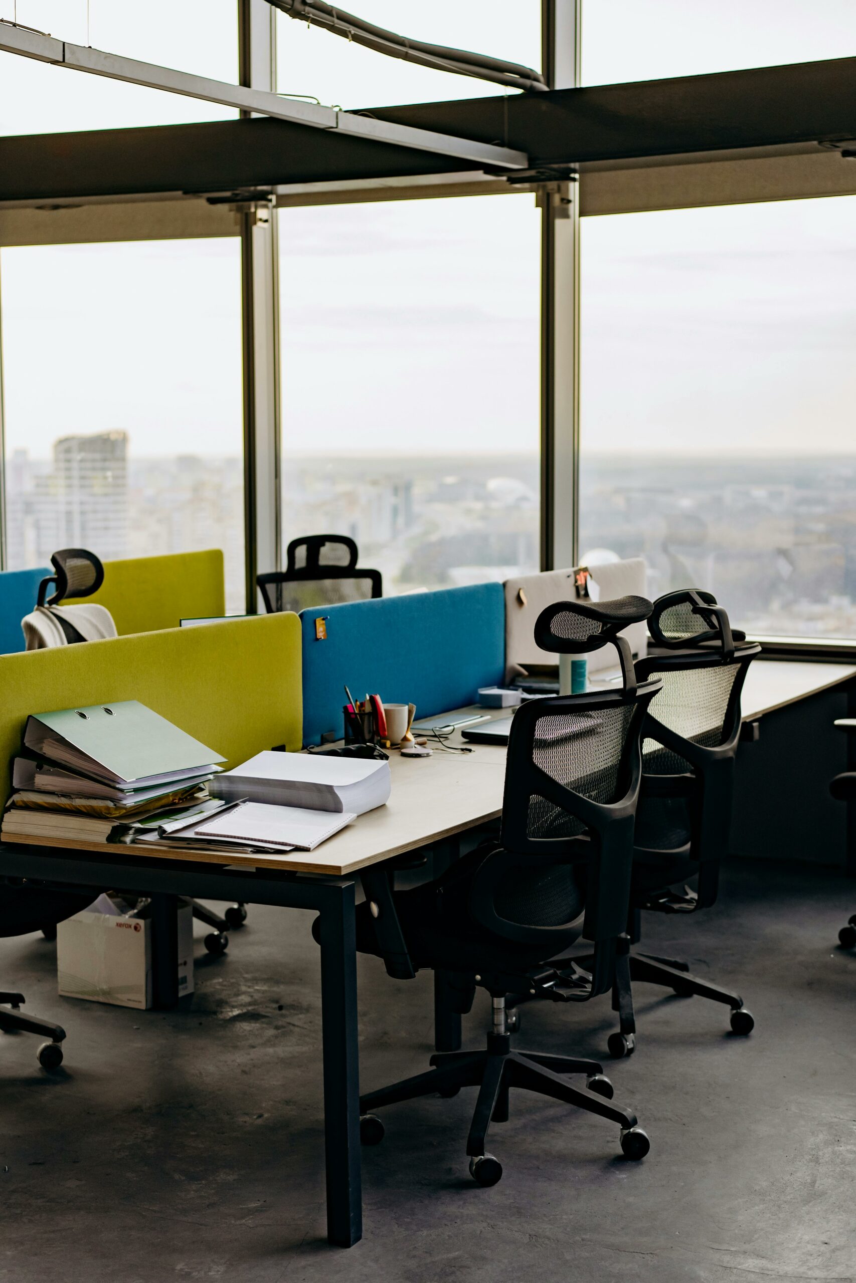 Oficina equipada con escritorio y sillas con vistas a la ciudad