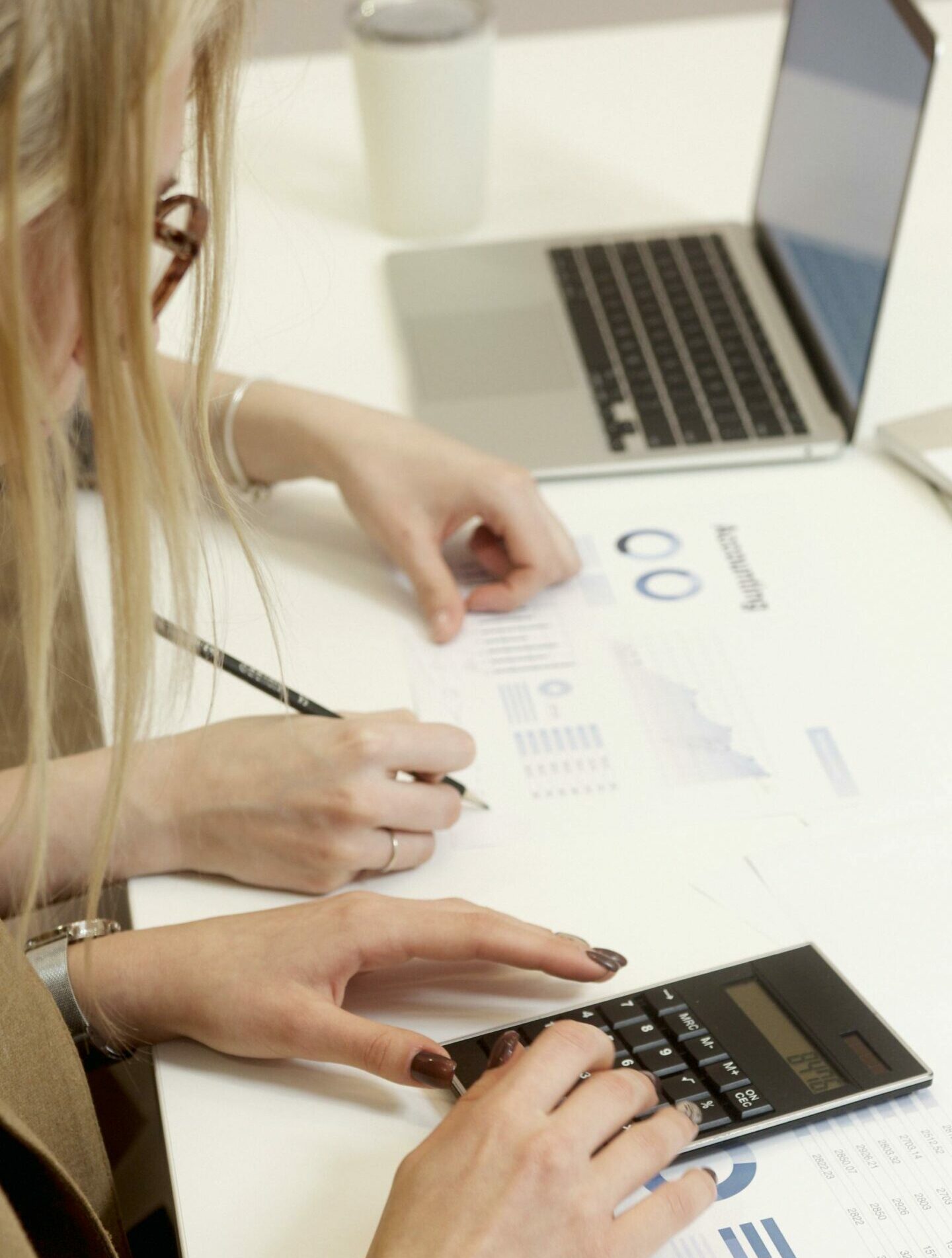 mujer en escritorio calculando costes